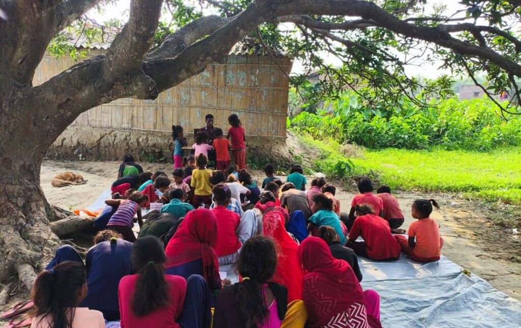 Children studying under a tree at the non-formal education centre